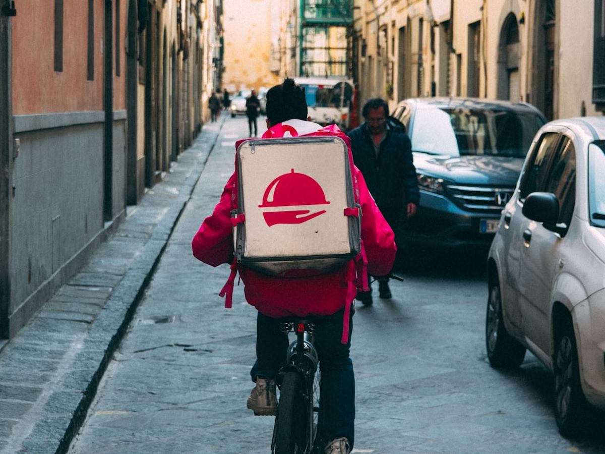 Food delivery rider carrying an insulated bag through the city