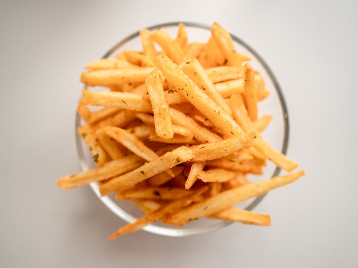 Loaded fries topped with cheese sauce and herbs